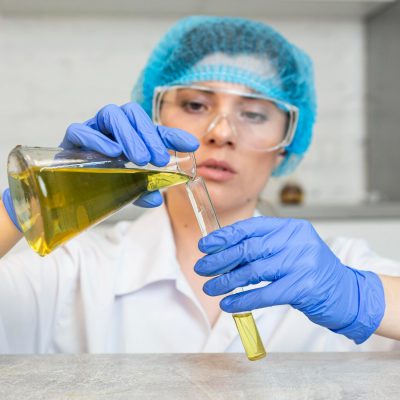 Vědkyně přelévá olej do zkumavky